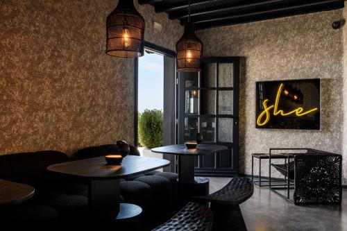 un restaurante con 2 mesas y sillas y una ventana en She Mykonos Boutique Hotel en Mykonos ciudad