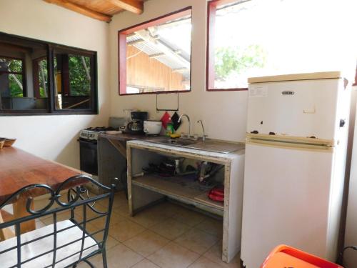 Una cocina con un refrigerador blanco y una estufa. en Chill-Inn Nosara, en Nosara
