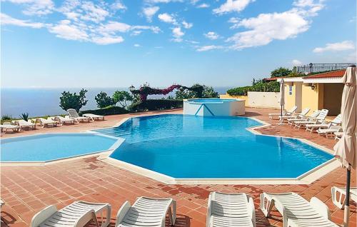 a large swimming pool with chairs and a pool table at Casa Nardi in Parghelia