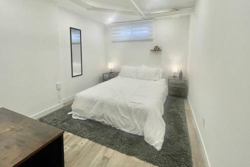 a white bedroom with a large bed with white sheets at Urban KW Gem - Private 2 Bedroom Apartment ! in Kitchener