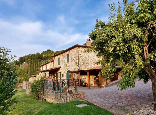 マッサ・マリッティマにあるAgriturismo Bike Hotel Podere Giarlingaの木の前の古い石造建築