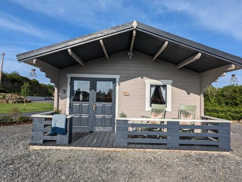 a tiny house with two chairs on a deck at Westport Country Chalets in Westport