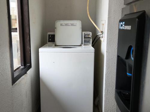 a small refrigerator with a laptop on top of it at Express Inn Tomball in Tomball