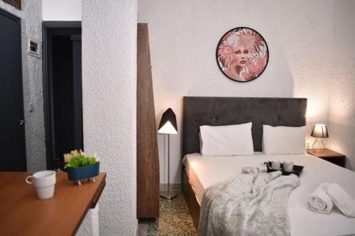 1 dormitorio con 1 cama y reloj en la pared en PELEKAN rooms and apartments ATHINA 23, en Pefkohori