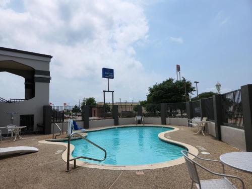 a small swimming pool with chairs and a table at Express Inn Tomball in Tomball