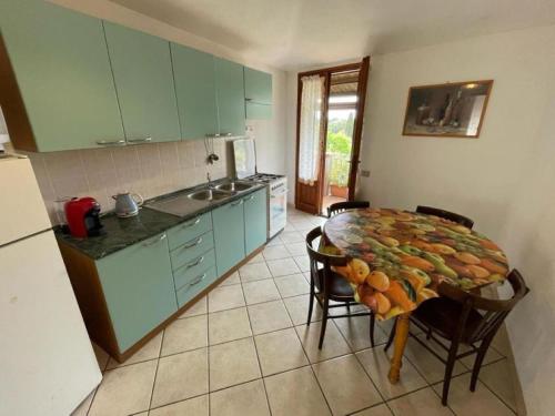 a kitchen with a table and chairs in a kitchen at Appartamenti Su Pasiu in Chia