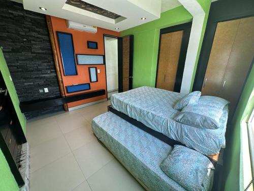 a bedroom with two beds in a room with green walls at Isla Cozumel in Acapulco