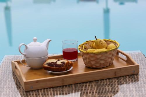 a tray with a tea pot and a basket of food at Agri Resort Masusa in Aquara