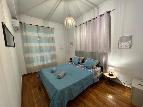 1 dormitorio con cama azul y almohadas azules en ATHENS 3br Riviera Alimos, en Atenas