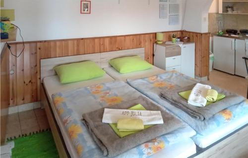 1 Schlafzimmer mit 2 Betten und grünen Kissen in der Unterkunft Nice Apartment In Martinscica With Wifi And 1 Bedrooms in Martinšćica