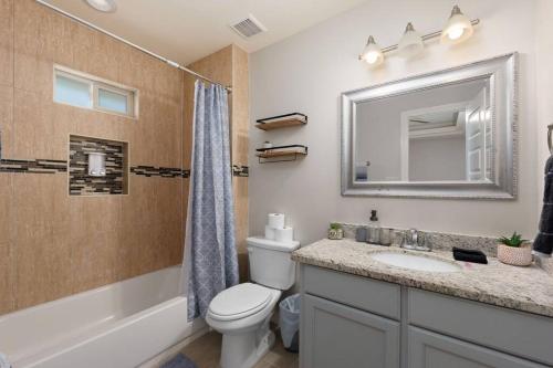 a bathroom with a toilet and a sink and a mirror at The Oaks Modern 3Bd/2Ba.Fast WiFi/Netflix in Edinburg