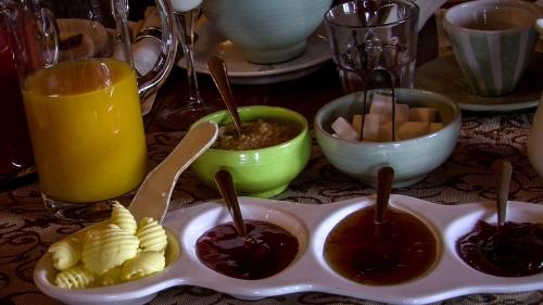 a table topped with bowls of food with spoons at Birds Ferry Lodge Luxury B&B in Westport