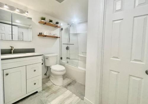 a white bathroom with a toilet and a shower at Urban KW Gem - Private 2 Bedroom Apartment ! in Kitchener