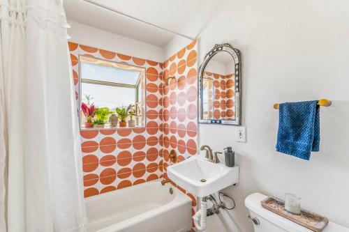 an orange and white bathroom with a sink and a toilet at The Maude House in Twentynine Palms