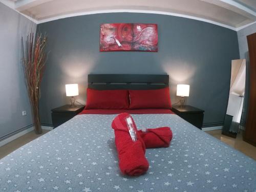a red stuffed animal laying on a bed in a bedroom at FINCA CAL TARRÉ - Alojamientos turísticos in Campdevánol
