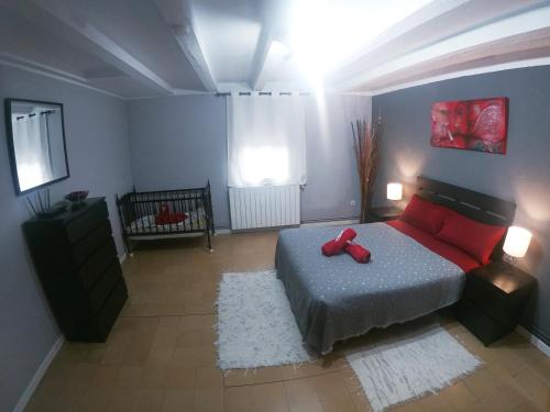 a bedroom with a bed with a red stuffed animal on it at FINCA CAL TARRÉ - Alojamientos turísticos in Campdevánol