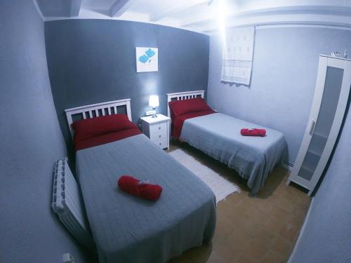 a bedroom with two beds with red pillows on them at FINCA CAL TARRÉ - Alojamientos turísticos in Campdevánol