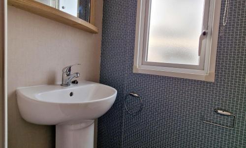y baño con lavabo y espejo. en Modern 6 Berth Caravan With Wifi At Martello Beach In Essex Ref 28008pm, en Clacton-on-Sea