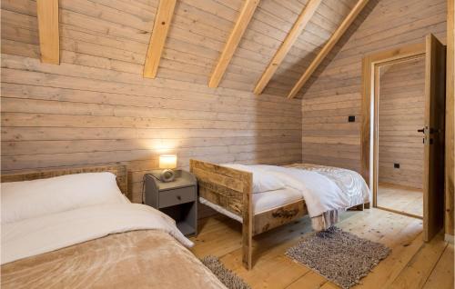 2 camas en una habitación con paredes de madera en Nice Home In Mrkopalj With Kitchen, en Mrkopalj