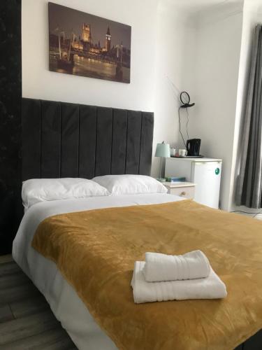 a bedroom with a large bed with two towels on it at Double Room Central Location in London