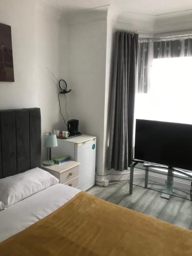 1 dormitorio con 1 cama, TV y ventana en Double Room Central Location, en Londres