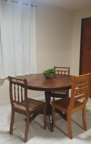 a wooden table with two chairs and a bowl on top at Pousada Morada dos Pássaros in Pedro Leopoldo