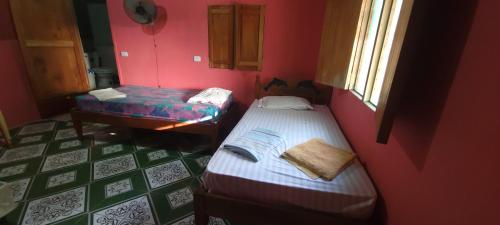 a small room with two beds and a table at Hostal Maria in Rivas