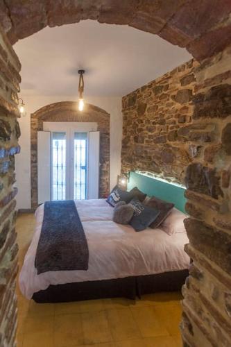 a bedroom with a large bed in a stone wall at La Esquinita in Tarifa