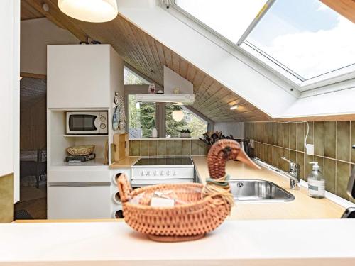 a kitchen with a sink and a basket on a counter at 4 person holiday home in Idestrup in Marielyst