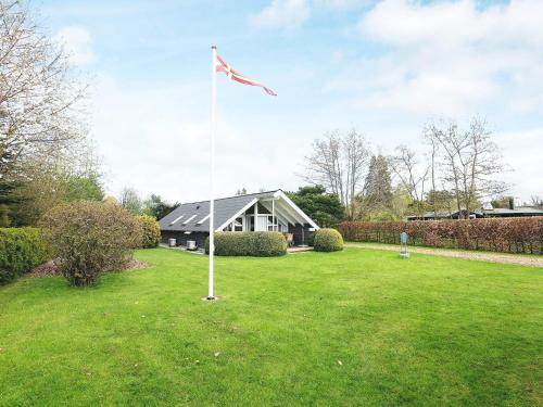 un poste de bandera en un patio con una casa en 4 person holiday home in Idestrup en Bøtø By