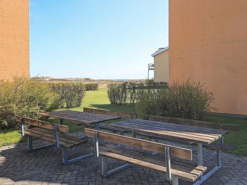 three wooden benches sitting next to a building at 4 person holiday home in Hals-By Traum in Hals