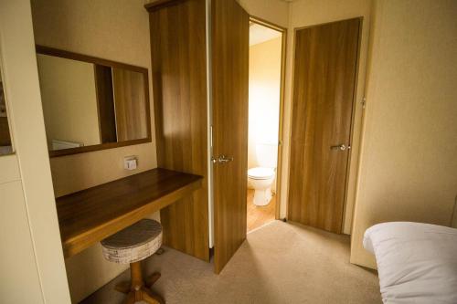 a bathroom with a desk and a toilet in a room at Lovely Caravan With Decking At Millfields Caravan Park Ref 87025f in Skegness