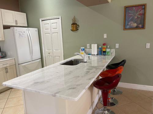a kitchen with a counter with a sink and a refrigerator at Pool Home in Englewood
