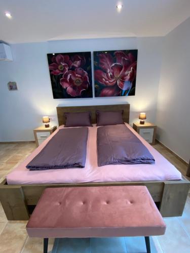 a bedroom with a large bed with pink sheets at Nice Place in Stanići
