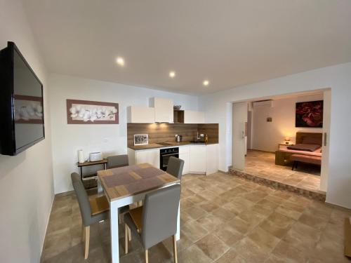 a kitchen and living room with a table and a dining room at Nice Place in Stanići