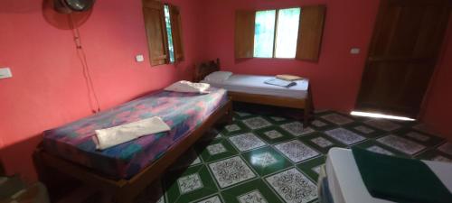 a small room with two beds and a window at Hostal Maria in Rivas