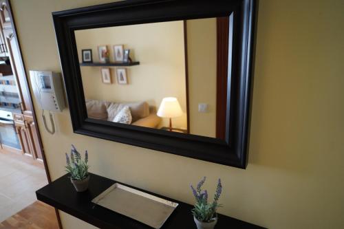 un miroir sur le mur du salon dans l'établissement ALMAR, Apartamento en Luanco., à Luanco
