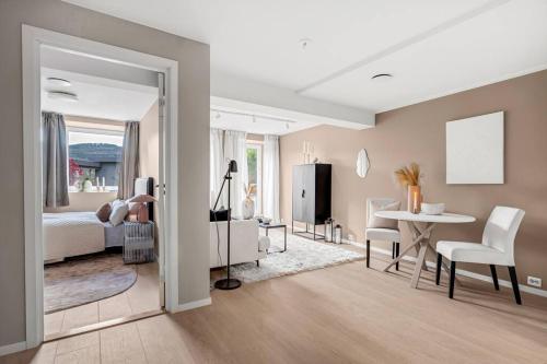a bedroom with a bed and a table and a dining room at Sentral v Nidelva in Trondheim