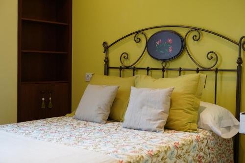 Schlafzimmer mit einem Bett mit einem Kopfteil aus Metall und Kissen in der Unterkunft ALMAR, Apartamento en Luanco. in Luanco