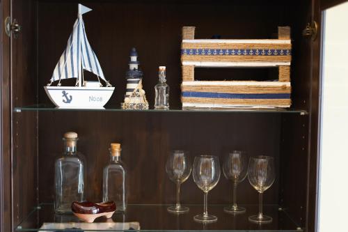 un estante con copas de vino y un barco en él en ALMAR, Apartamento en Luanco., en Luanco