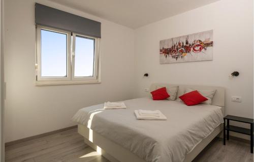 a white bedroom with a large bed with red pillows at Nice Home In Valtura With Kitchen in Valtura