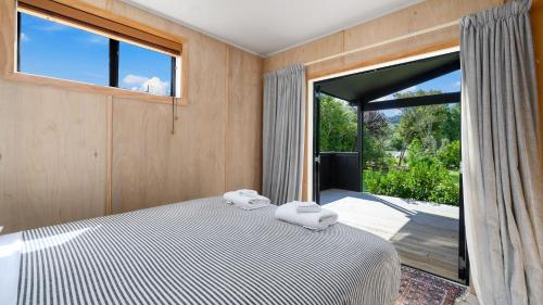 a bedroom with a bed and a large window at Tongariro Adventures The Lodge in Kuratau