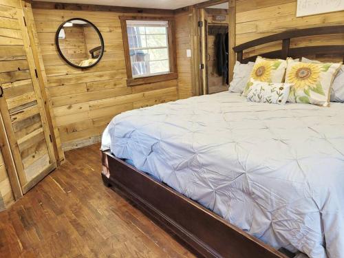 Hot Tub Private Cabin 5 min to College Station في Navasota: غرفة نوم بسرير كبير في غرفة خشبية