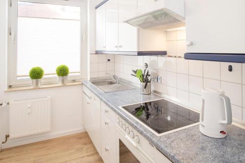 a white kitchen with a sink and a counter at 'Dörpnüst' in Langeoog