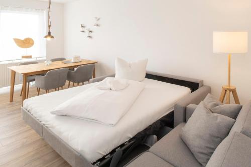 Ce lit se trouve dans un dortoir doté d'une table et de chaises. dans l'établissement 'Dörpnüst', à Langeoog