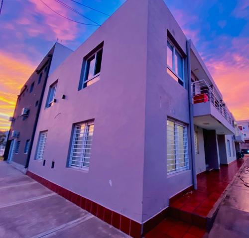 聖羅莎的住宿－Complejo Pampa 1，白色的建筑,背面有日落