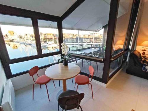 a room with a table and chairs and a large window at Chez Mamarina - Quadruplex - Marina Deauville in Deauville