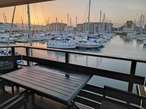a bench on a dock with boats in a marina at Chez Mamarina - Quadruplex - Marina Deauville in Deauville