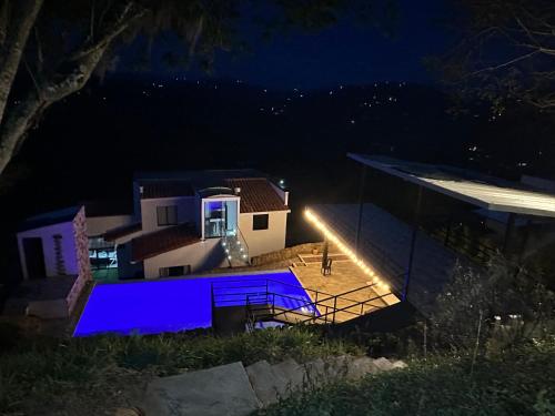 uma vista para uma casa à noite com uma luz azul em San Gil Villa 48 Palmaire em San Gil