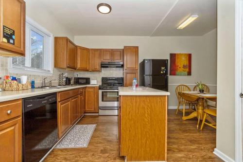 a kitchen with wooden cabinets and a table in it at 3 bedroom comfy RVA in Richmond
